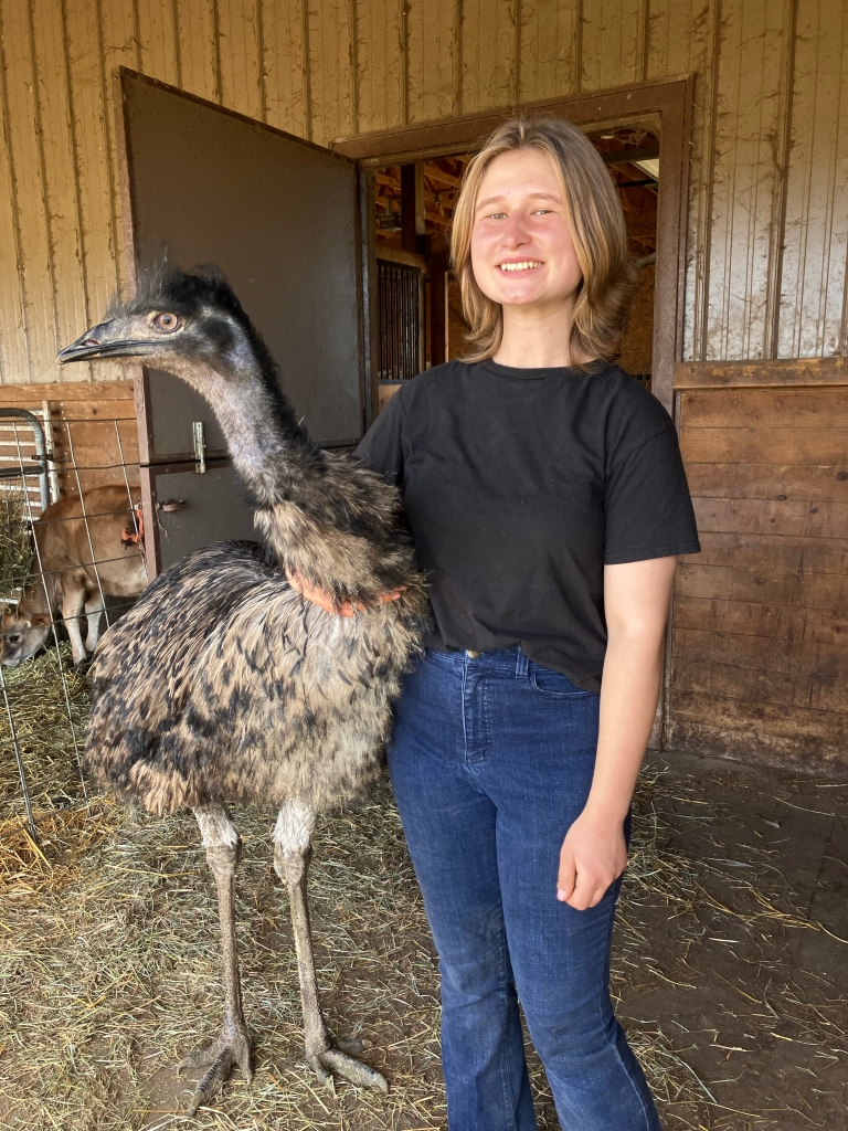 Leah Mishka standing next to one of her emus.