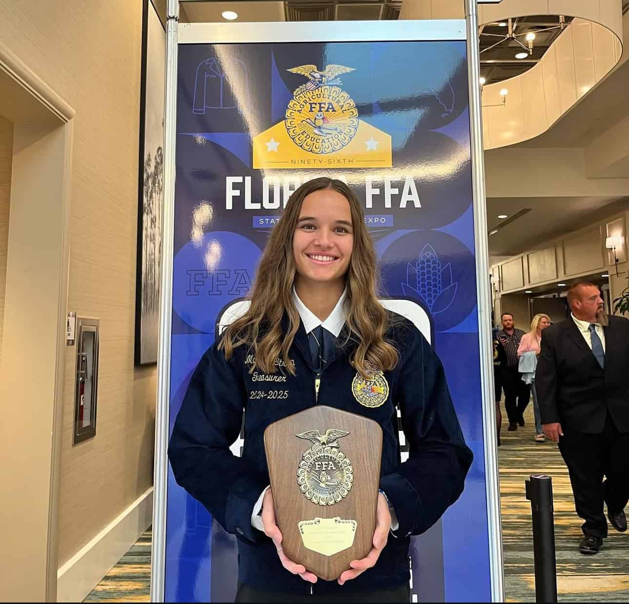 Madison Strain holds her Florida FFA proficiency finalist award.