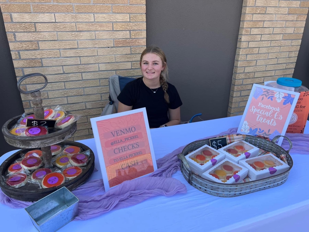 Ella Pickrel poses behind her booth at Fullerton’s annual Fall Festival in 2023.