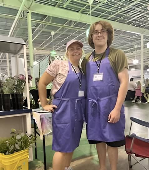 Conner and his mother, Celia, at their booth and work setup at a small business convention.