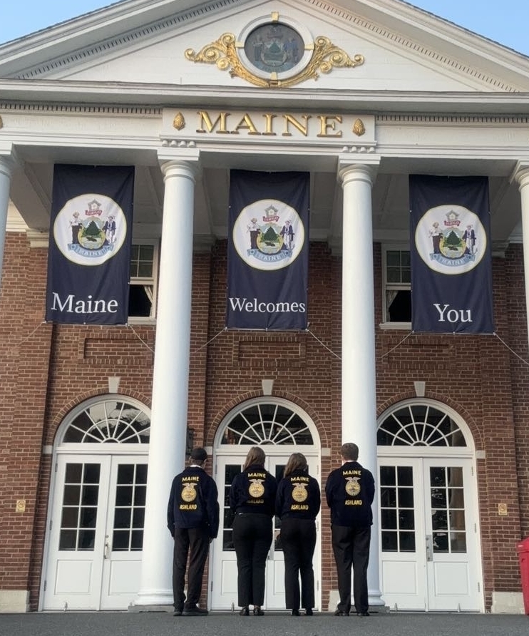 Farm Business Management team members in front of the Maine building at the Big E fairgrounds.