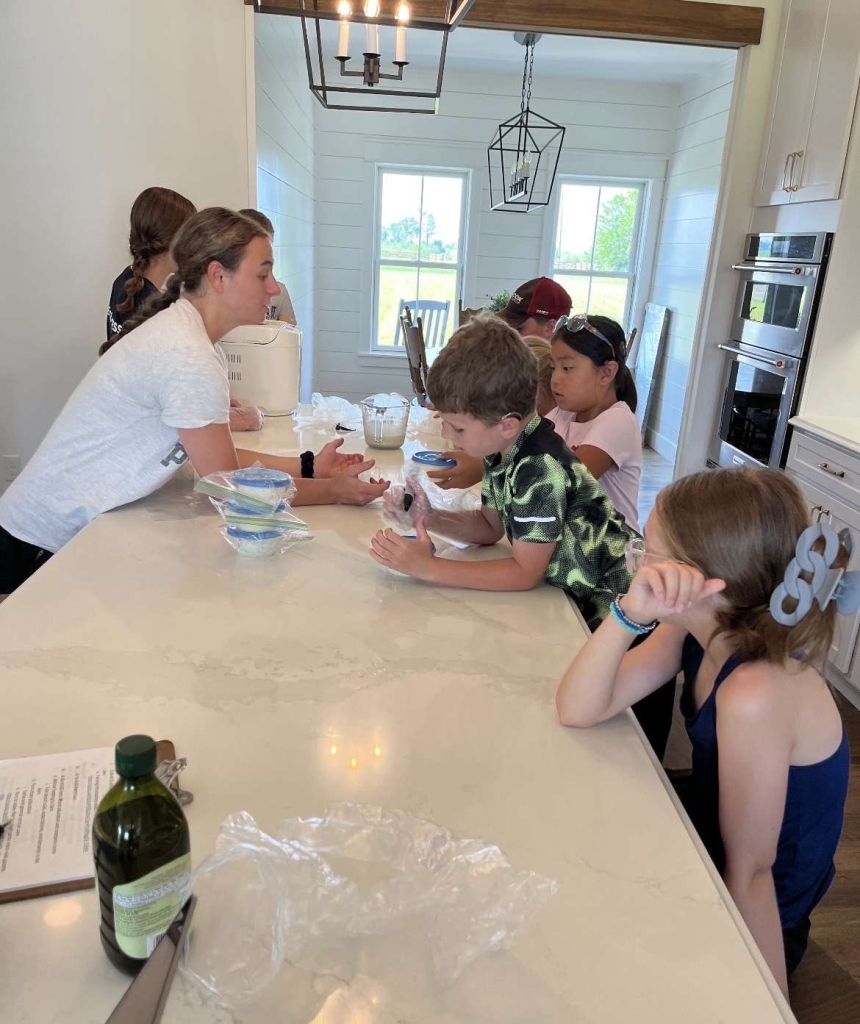 Ava and Lyla Susong teach a farm-to-table lesson to campers.