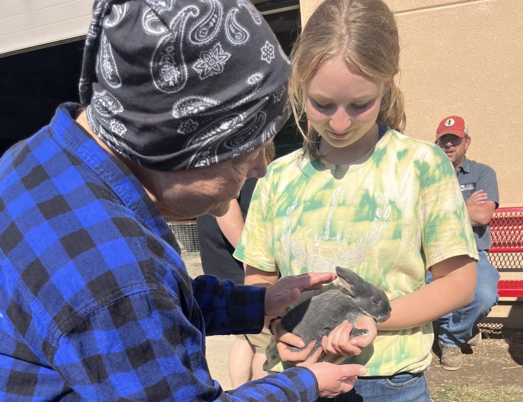 North Clay FFA member Isabella Barbee showcases her bunny to a visitor.