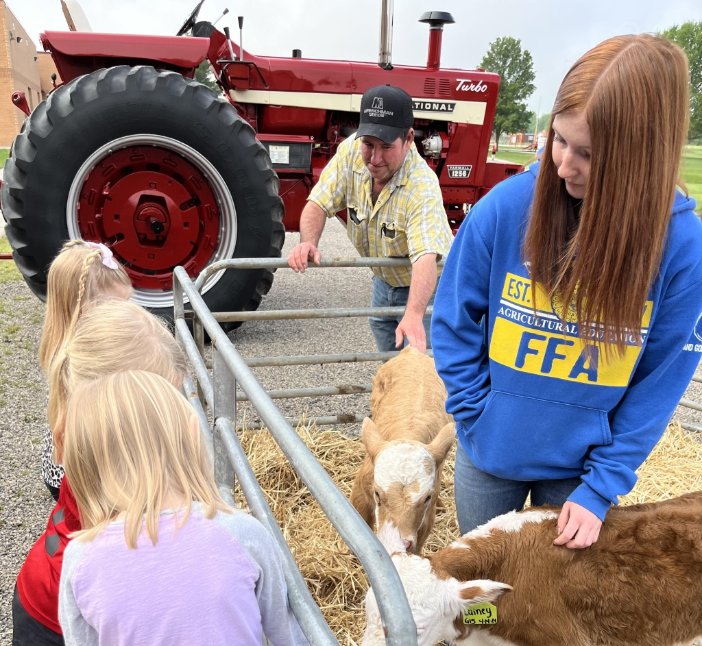 North Clay FFA member Shelly Pierson and alumni member Mark Pierson teach students about their bottle-fed calves.