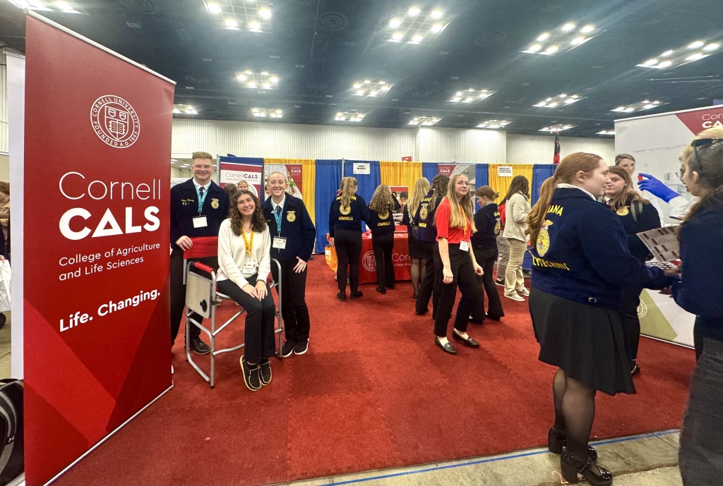 Past FFA member and New York FFA officer volunteering at the Cornell CALS booth, pictured with two current New York FFA members.