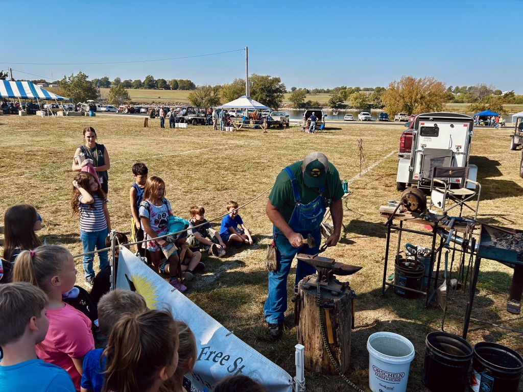 Participating students watch a blacksmith demonstration.