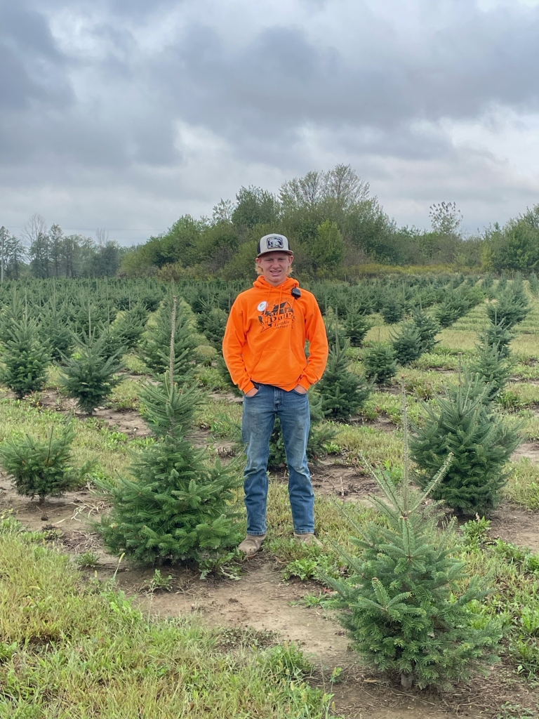 Johnson stands with the Christmas trees growing at Dull’s Tree Farm.