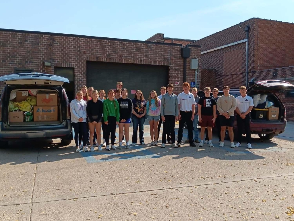 Fullerton High School's animal science class poses next to the vehicles loaded with supplies.