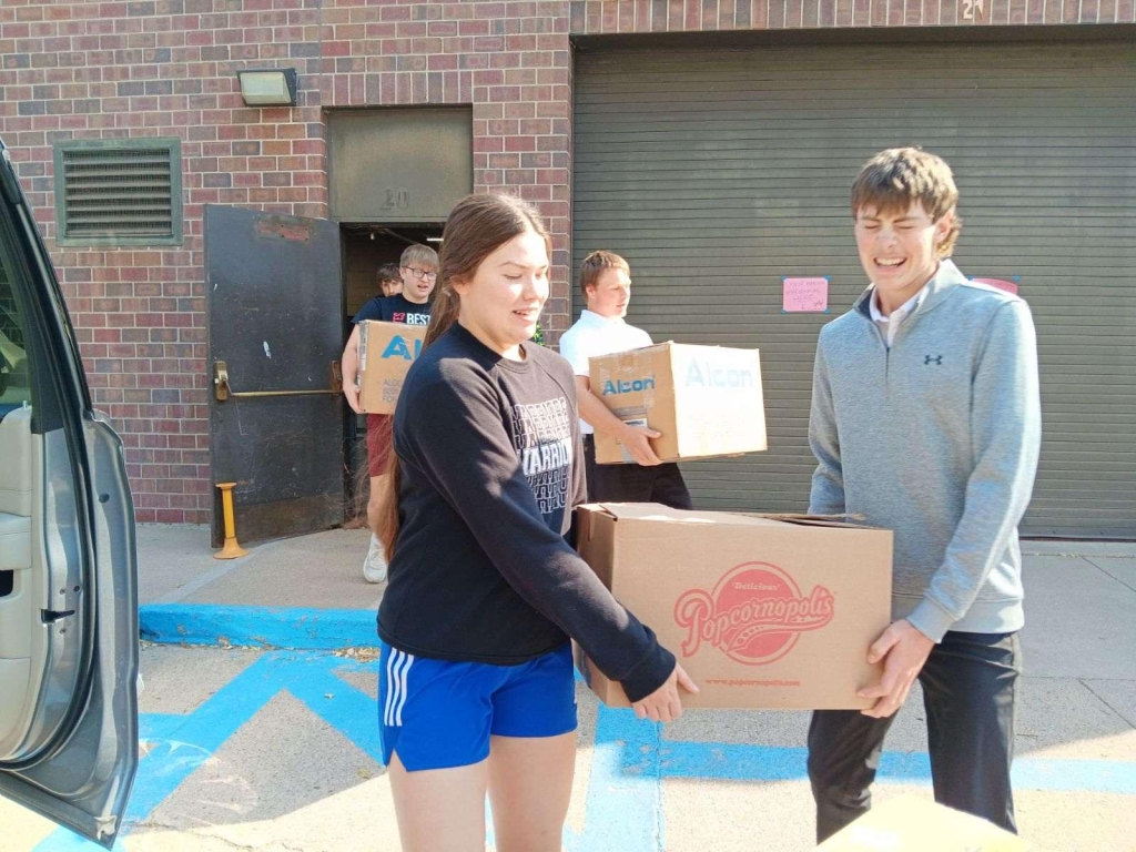 Fullerton High School junior Georgia Bridger and senior Nolan Dubas carry a box of donated supplies.