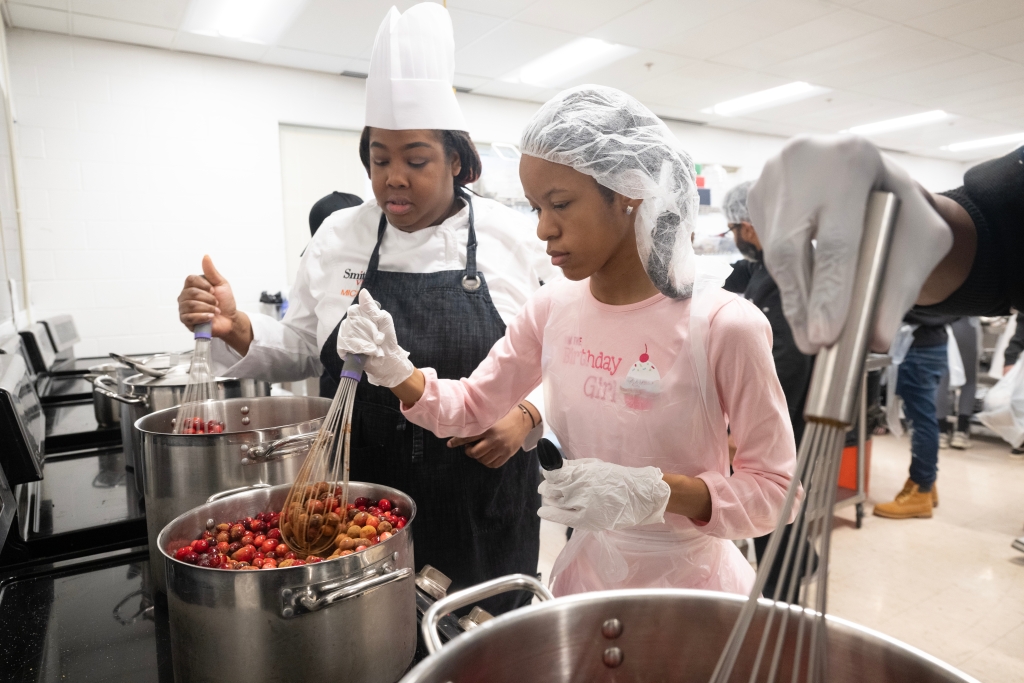 Chef Michelle Sandifer (left) assists junior food science pathway student Simone Shelton (right). 