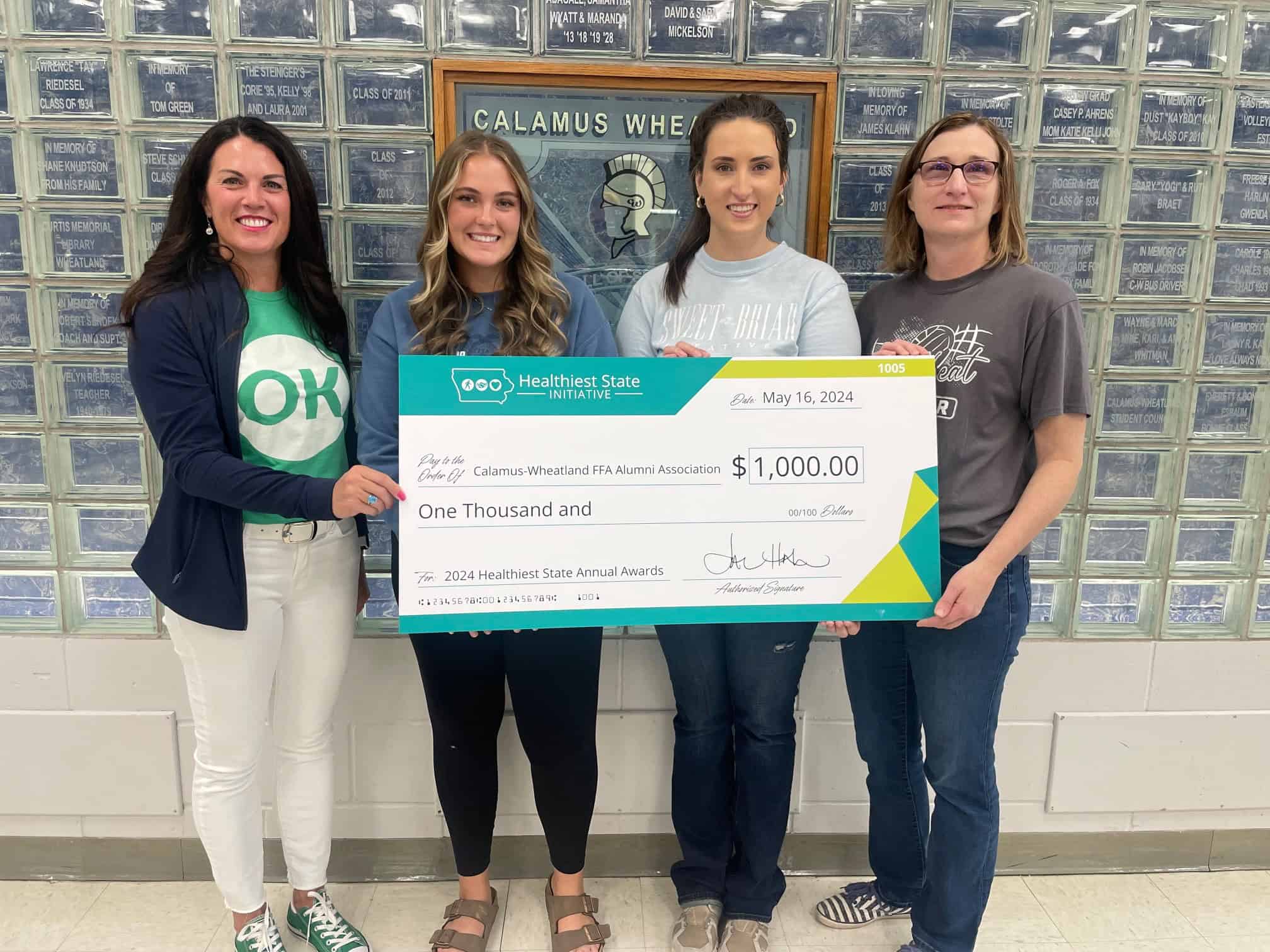 In addition to her produce, Schroeder has donated $4250 back to the community from awards she has won. Here her FFA Chapter is the recipient of $1000 from Iowa Healthiest State Initiative