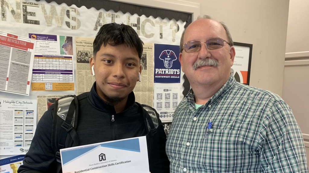 FFA advisor and teacher Jeff McKinney (right) celebrates with Kevin Ramirez (left) after he earned his credential in residential construction skills. 