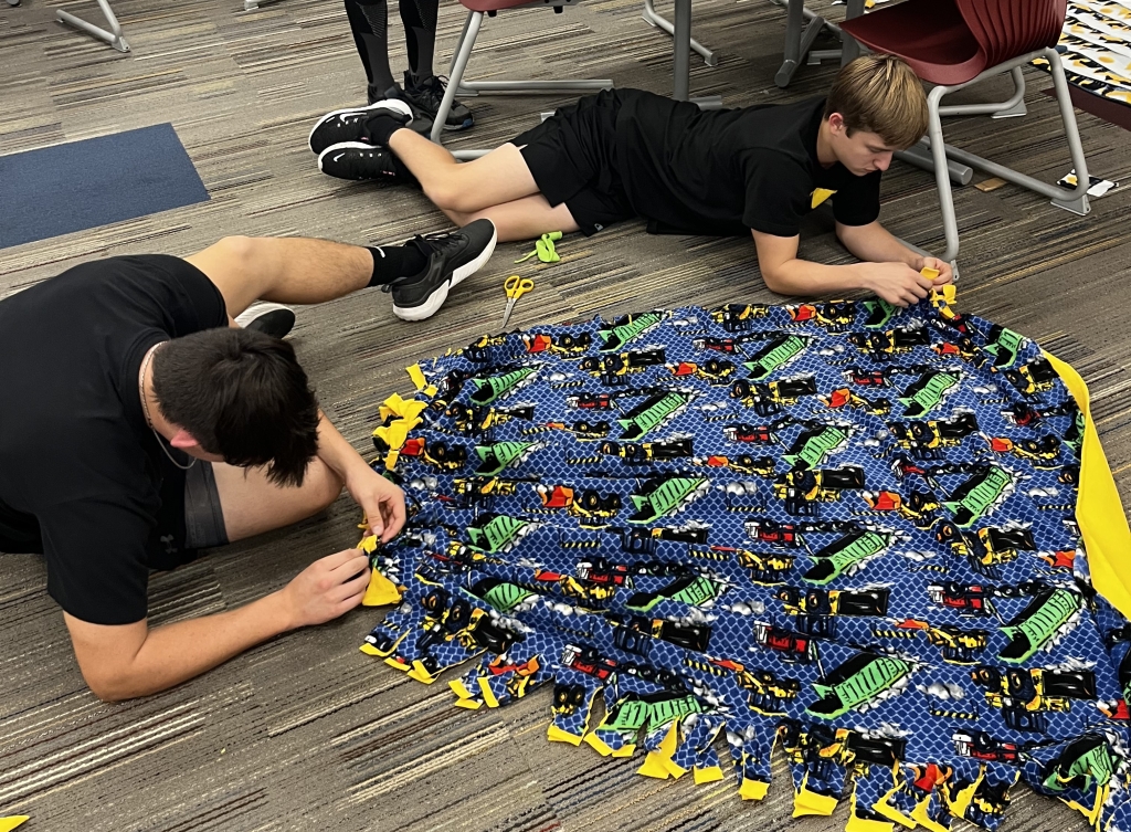 Members create the tie blankets.