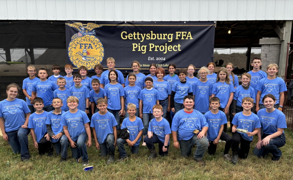 Gettysburg FFA members and Pig Project participants stand in front of the project banner.