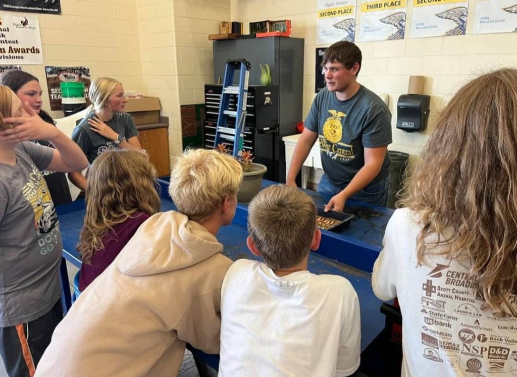 DeWitt Central FFA member Caden Bernauer teaches middle school agriculture students about succulents.