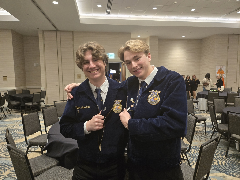 A Salinas FFA member and California FFA State Vice President John Dein trade Bigfoot and #TeachAg pins.