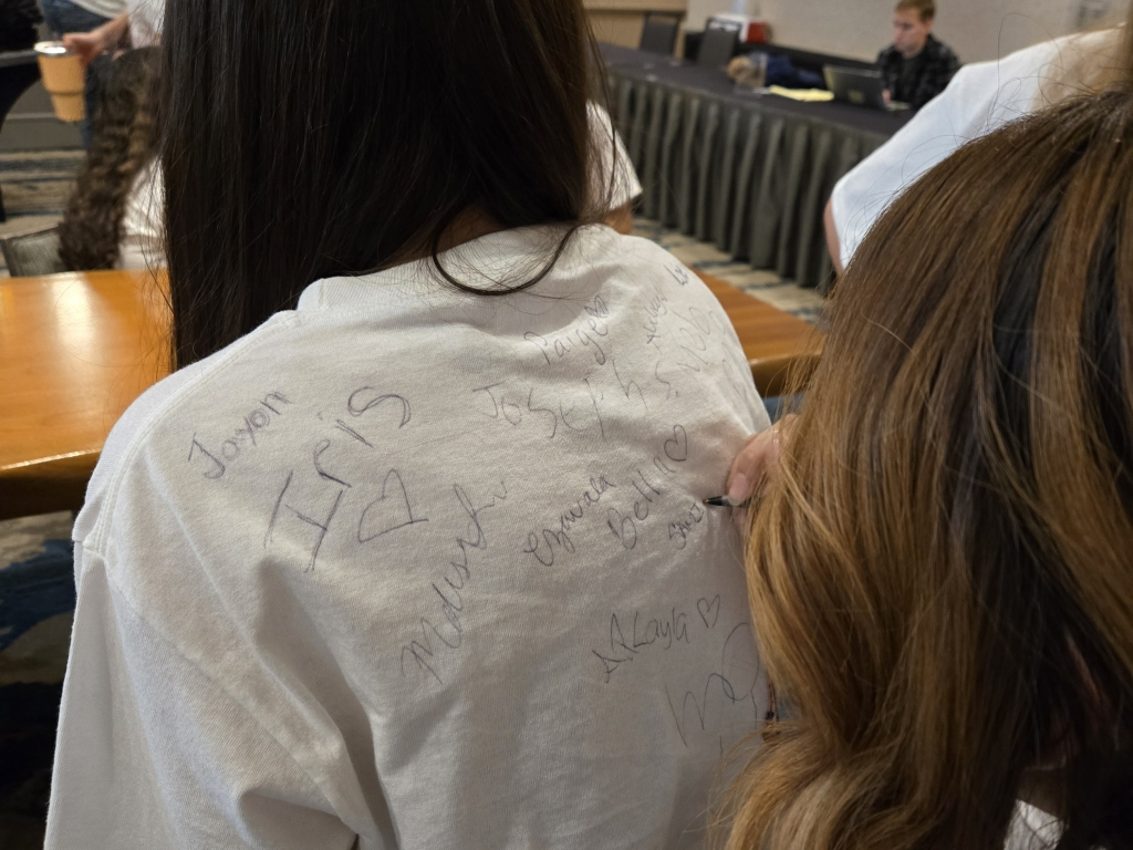 Members sign conference shirts after the last session.