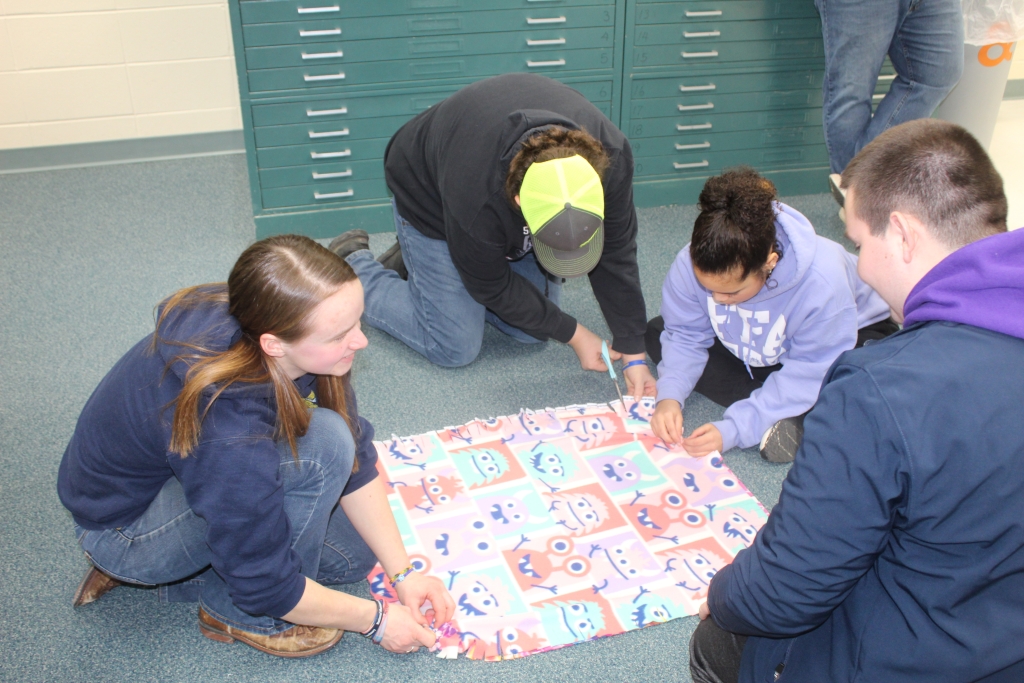 During the 2024 Lock-In, Granton FFA members make tie blankets that will be donated to area charities.