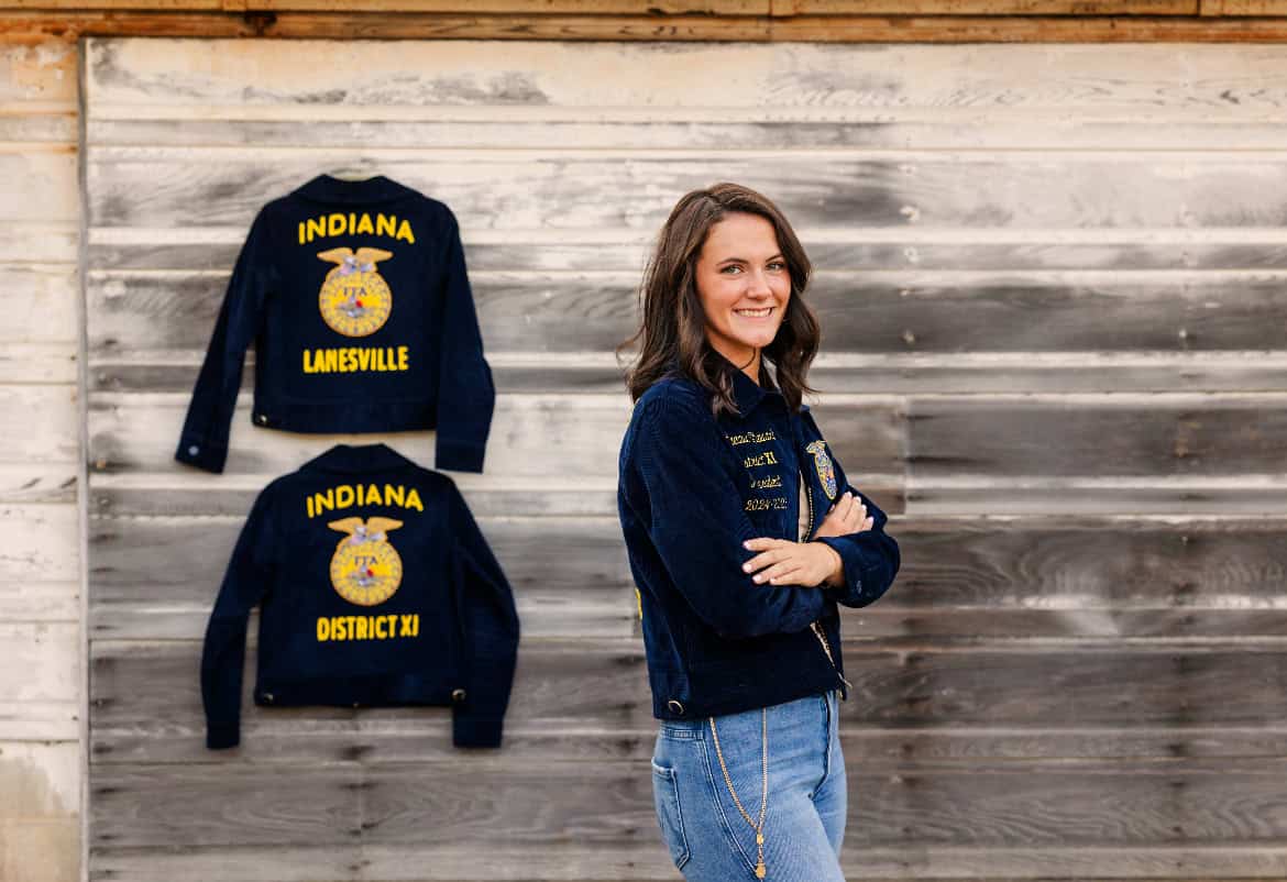 Margeaux Stewart, standing by her FFA jackets, showcasing her growth within the organization.