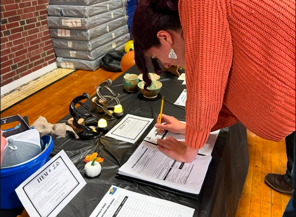 A community member signs an auction paper.