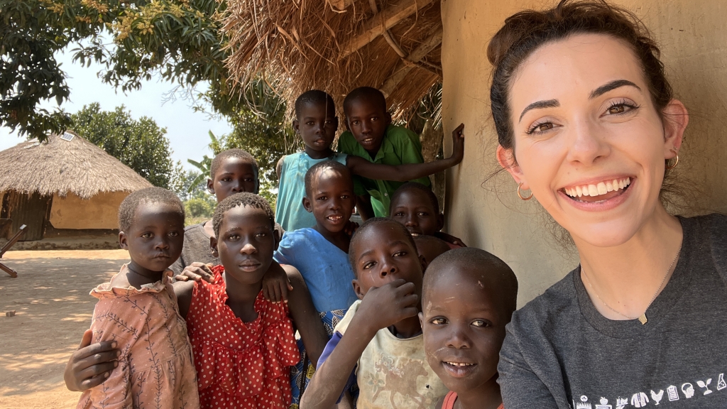 Anna Mathis (far right) smiles with children in a Ugandan village. Photo courtesy of Anna Mathis. 