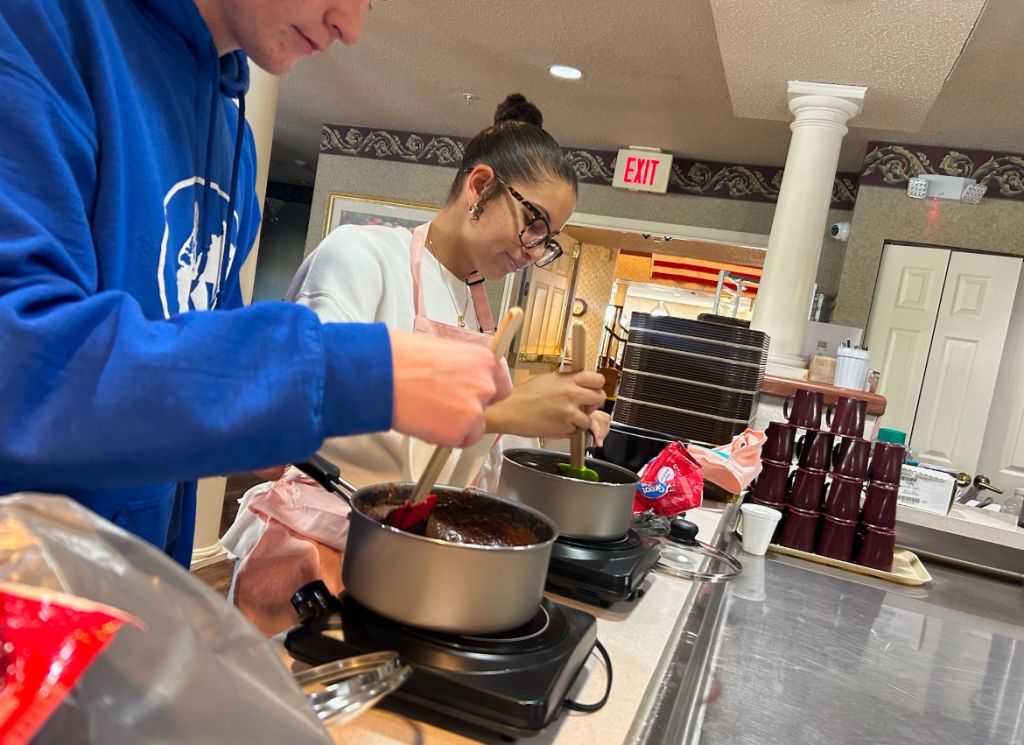 Owen Bigler, Chapter Sentinel, and Breanna Stratton, Chapter Vice President, preparing the sweet treats by melting chocolate.