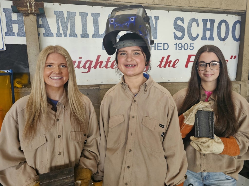 Kinsley Spearman, Macy Aycock and Claudia Hughes hold recent welds they completed.