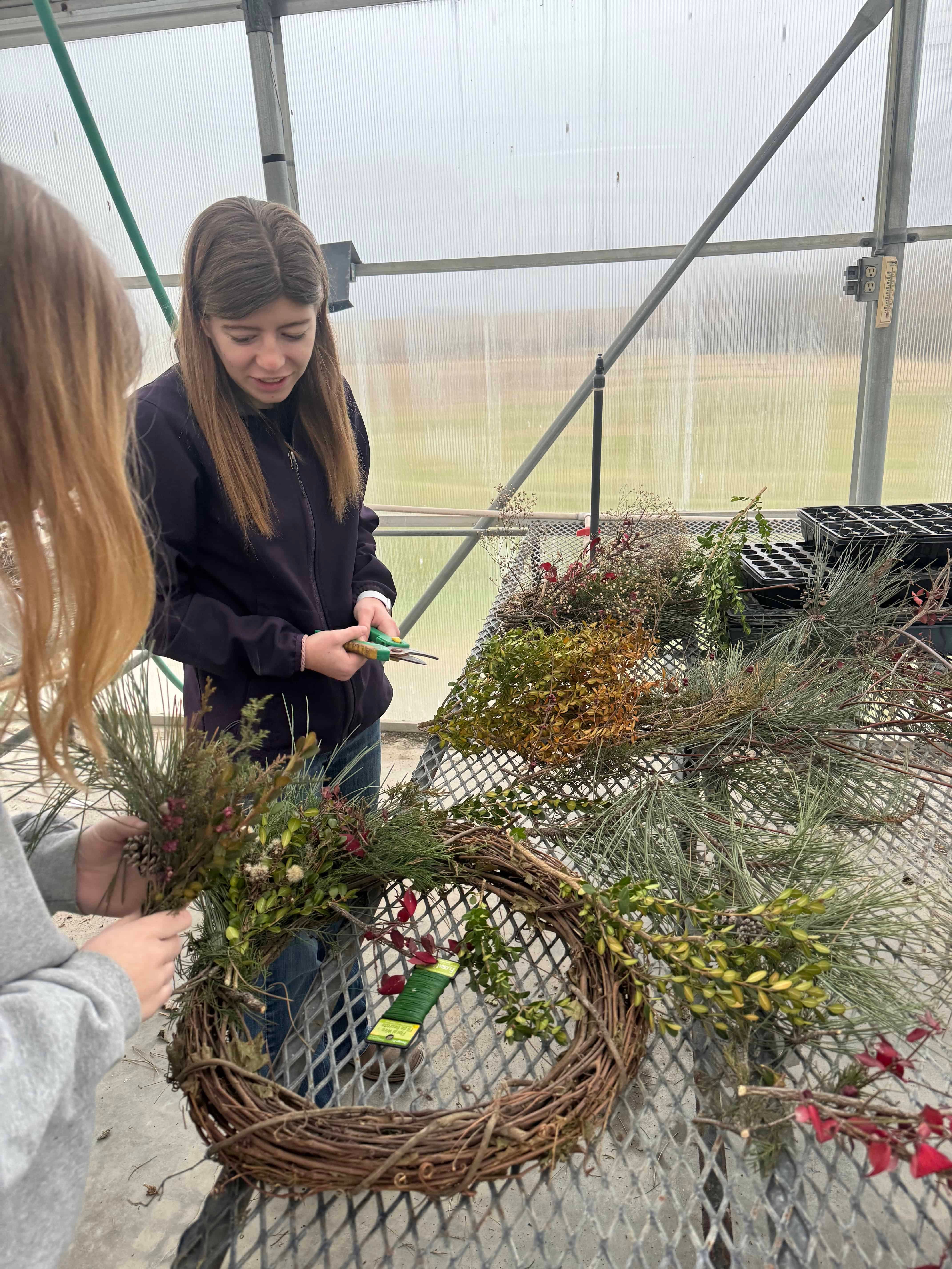 Senior Paige Powell and sophomore Hannah Matile construct a Christmas wreath in their horticulture class at Central Heights High School.