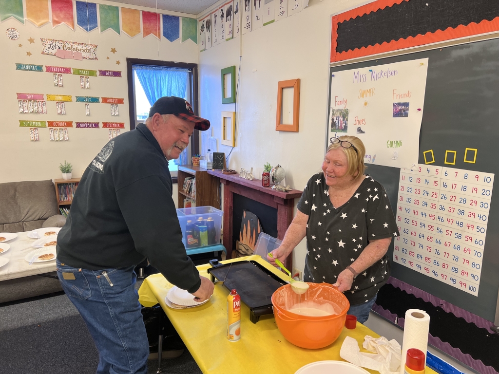 Alumni members Donny and Kim Thompson make pancakes.