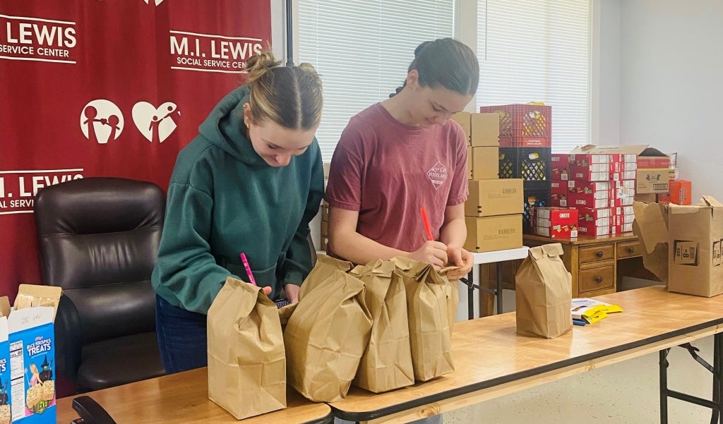 Friendswood FFA members Jaden Byers and Claire Appel decorate bags to be given to the community. 